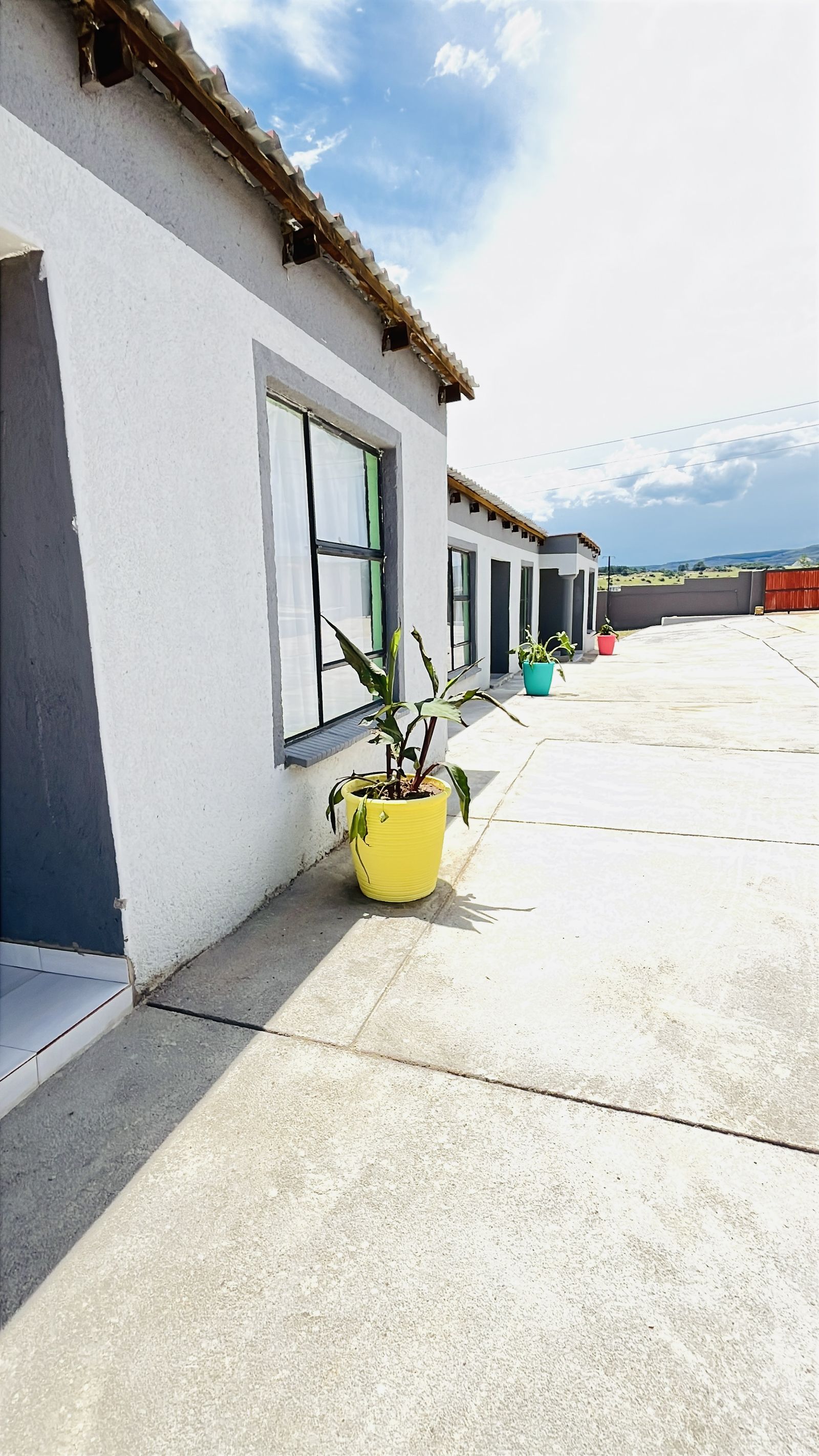 The guesthouse cottages with potted plants and open Mpumalanga views