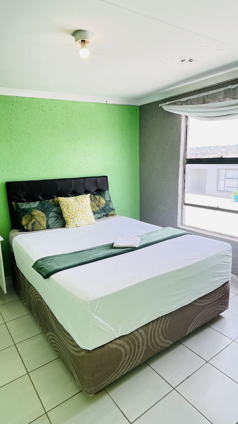 Room with black headboard and a view through the window