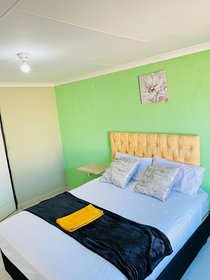 Cream tufted headboard against a fresh green wall